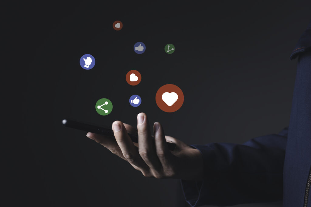 man holding a phone and social media icons